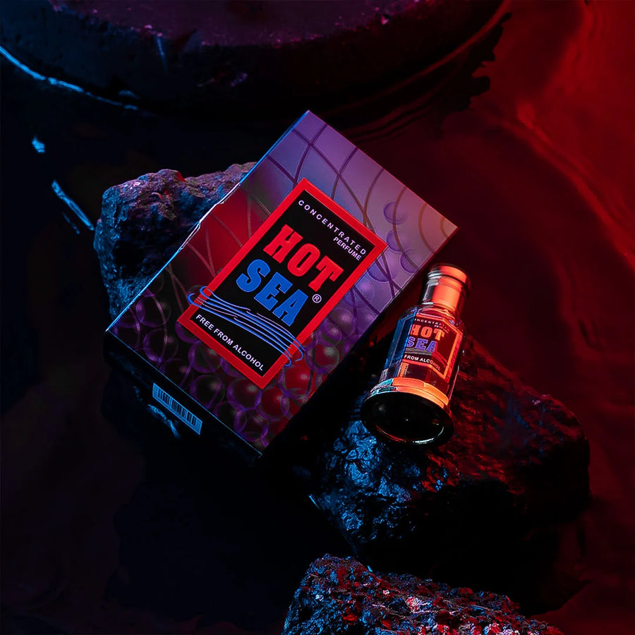Hot Sea concentrated perfume bottle and box on dark rocks with dramatic red and blue lighting